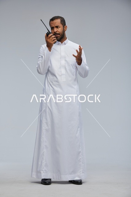 Saudi Man in White Thobe Using Walkie Talkie Radio