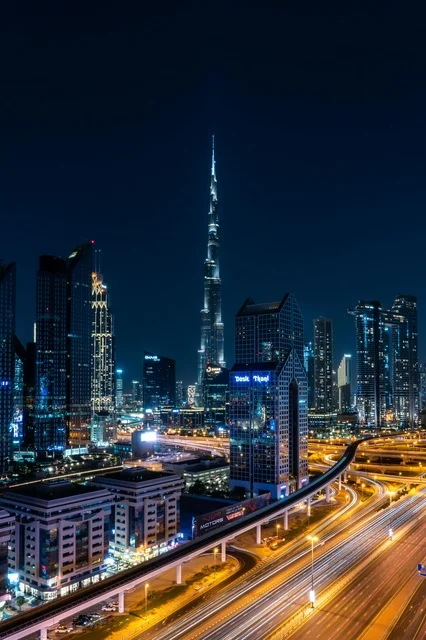 أفق مدينة دبي وبرج خليفة ليلاً مع مسارات الضوء