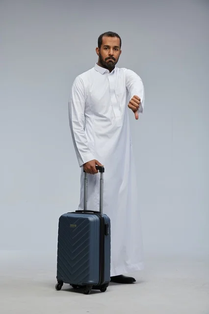 Saudi Man with Suitcase Making Thumbs Down Gesture