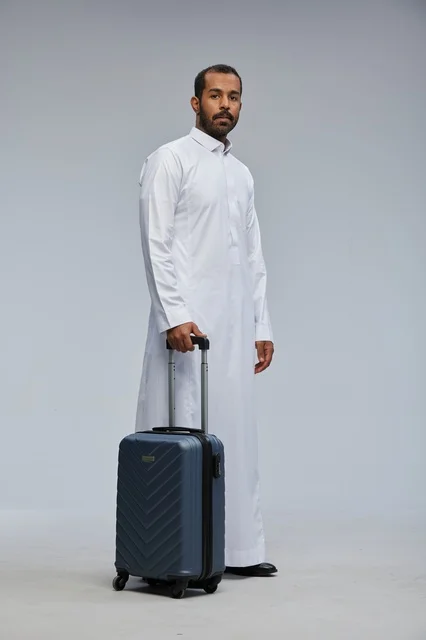 Saudi Man in White Thobe with Blue Travel Suitcase