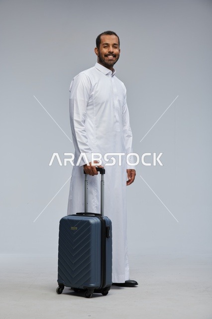 Saudi Man in White Thobe with Blue Travel Suitcase