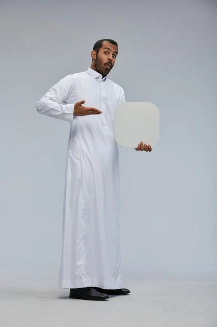 رجل سعودي بالثوب التقليدي يحمل لوحة بيضاء فارغة