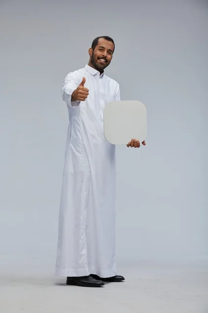 رجل سعودي بالثوب التقليدي يحمل لوحة بيضاء فارغة
