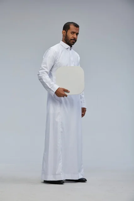رجل سعودي بالثوب التقليدي يحمل لوحة بيضاء فارغة