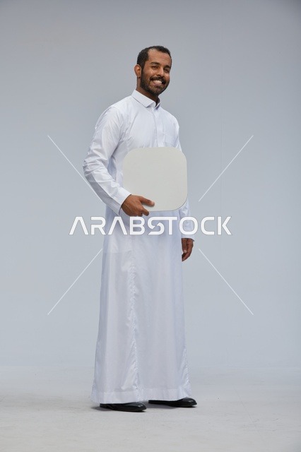 Saudi Man in Thobe Holding Blank Board in Studio