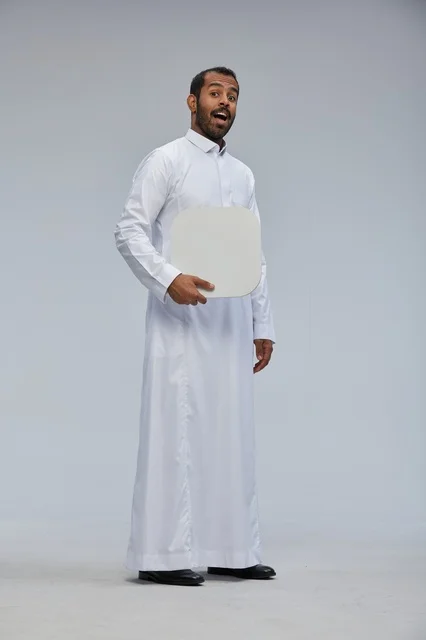 رجل سعودي يحمل لوحة بيضاء فارغة بتعبير متفاجئ