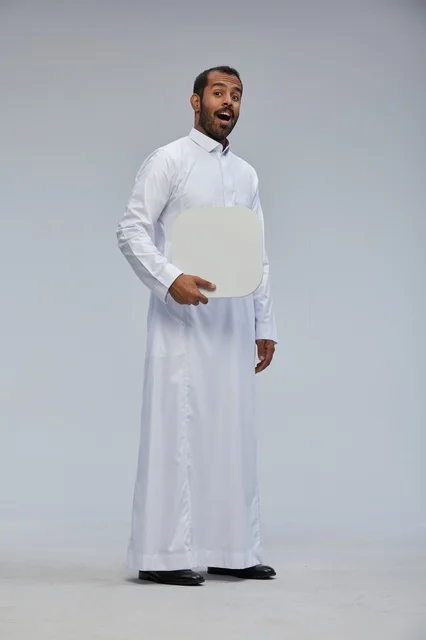 رجل سعودي يحمل لوحة بيضاء فارغة بتعبير مندهش