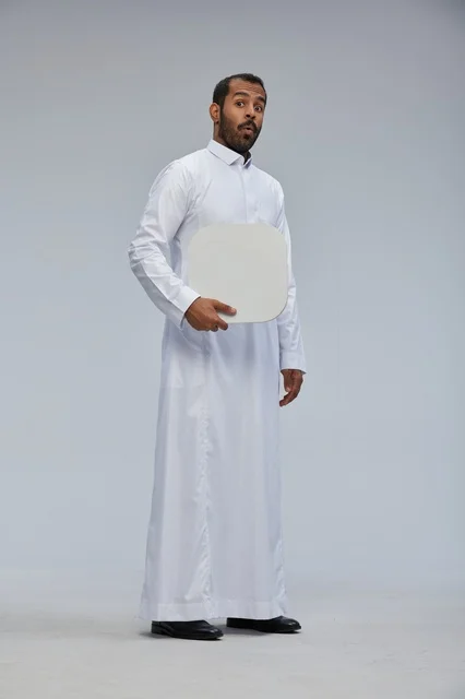 رجل سعودي يحمل لوحة بيضاء فارغة بملامح مندهشة