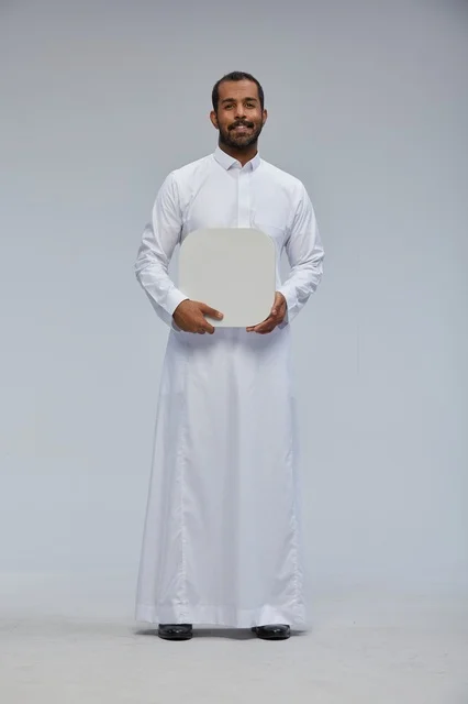 رجل سعودي يحمل لوحة بيضاء فارغة في الاستديو