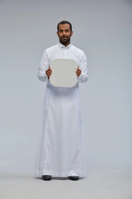 رجل سعودي بالثوب التقليدي يحمل لوحة بيضاء فارغة