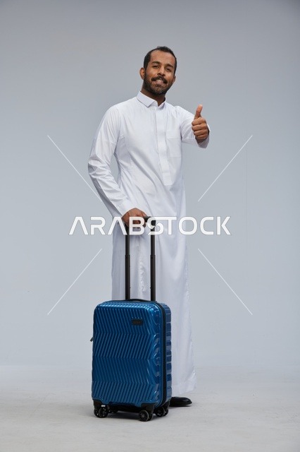 Saudi Man in White Thobe with Blue Suitcase Thumbs Up