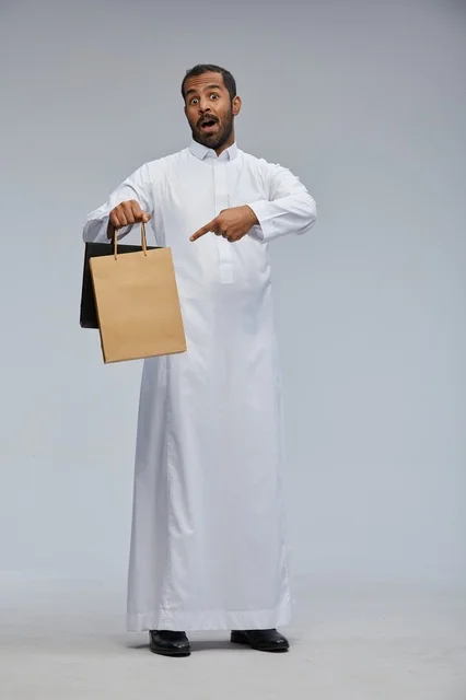 رجل سعودي يحمل أكياس تسوق بالثوب الأبيض