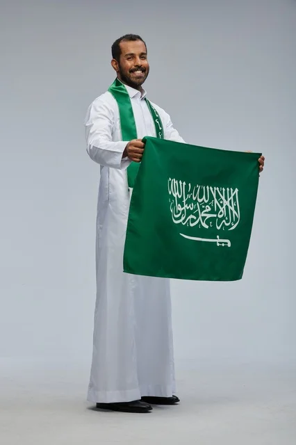 Saudi Man Holding National Flag in Studio Portrait