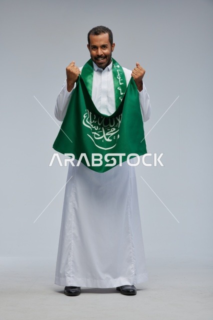 Saudi Man Holding National Flag Celebrating in Studio