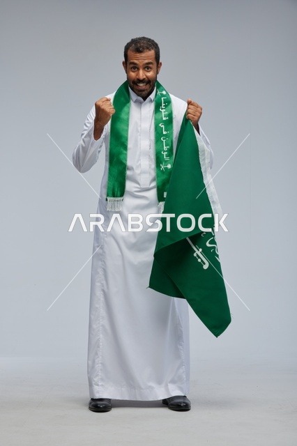 رجل سعودي يحمل العلم الوطني السعودي في احتفال اليوم الوطني
