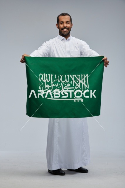 Saudi Man Holding National Flag in Studio Portrait