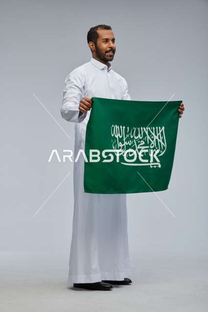 Saudi Man Holding Saudi National Flag in Studio Shot
