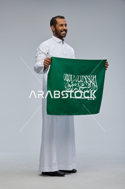 Saudi Man Holding National Flag in Studio