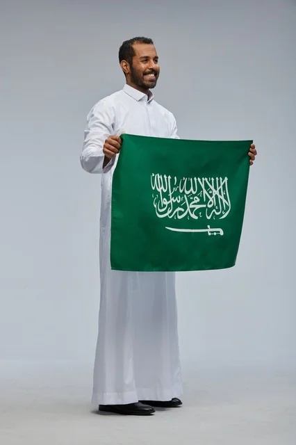 رجل سعودي يحمل العلم الوطني في الاستوديو