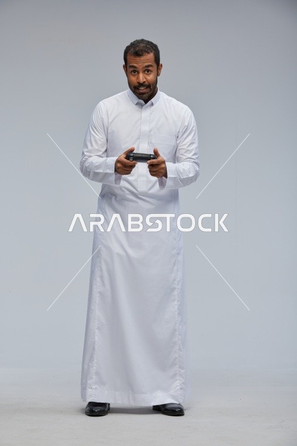 Saudi Man in Traditional Thobe Gaming in Studio