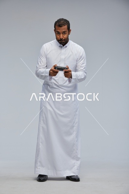 Saudi Man in Traditional Thobe Playing Video Games