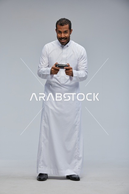 Saudi Man in Thobe Holding Video Game Controller