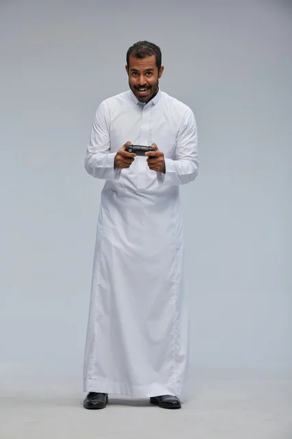 Saudi Man in Thobe Holding Video Game Controller