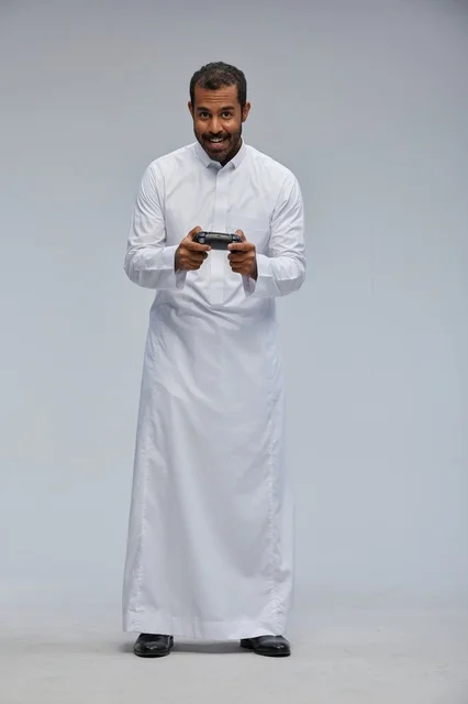 Saudi Man Playing Video Games in Traditional Thobe