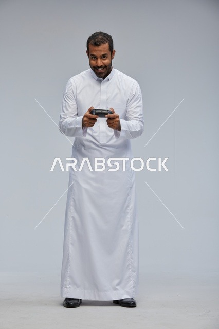 Saudi Man Playing Video Games Wearing Traditional White Thobe