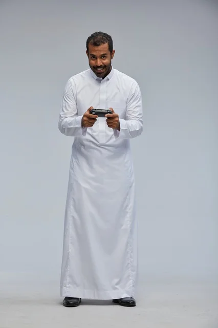 Saudi Man Playing Video Games Wearing Traditional White Thobe