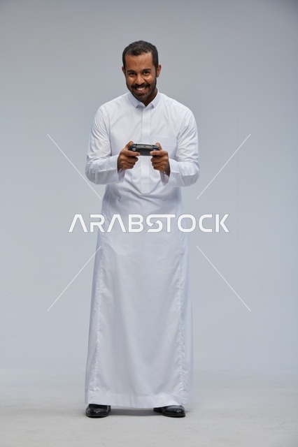 Saudi Man in Thobe Holding Video Game Controller