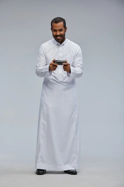 Saudi Man in Thobe Holding Video Game Controller