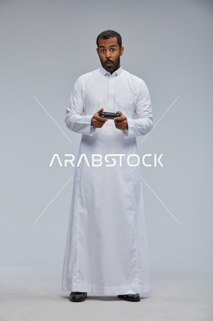Saudi Man in Thobe Holding Video Game Controller
