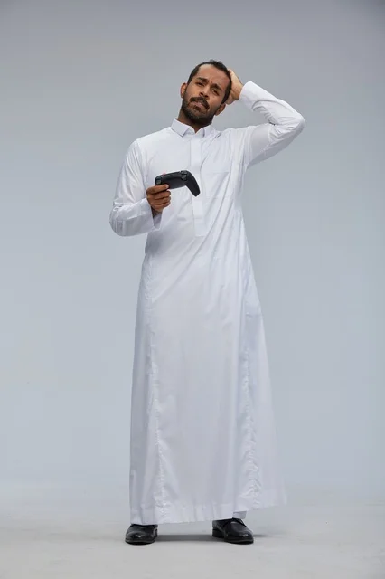 Saudi Man in Thobe Holding Gaming Controller Confused