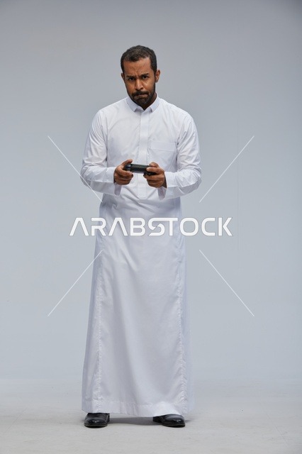 Saudi Man with Game Controller on Grey Background