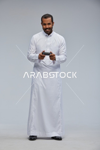 Saudi Man in Traditional Thobe Holding Gaming Controller