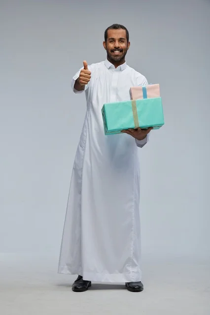 رجل سعودي بالثوب التقليدي يحمل صناديق هدايا