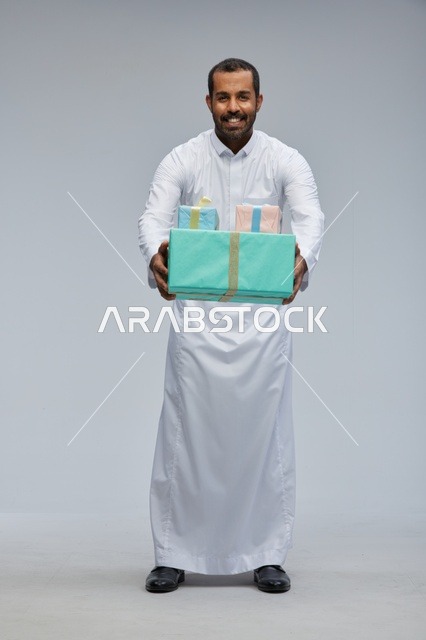 Saudi Man in Traditional Thobe Holding Gift Boxes