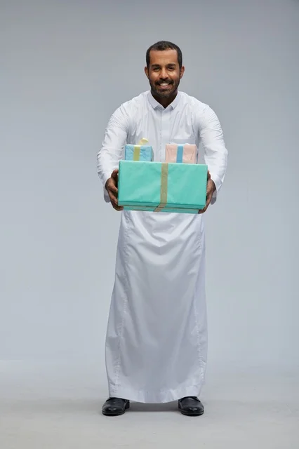 Saudi Man in Traditional Thobe Holding Gift Boxes