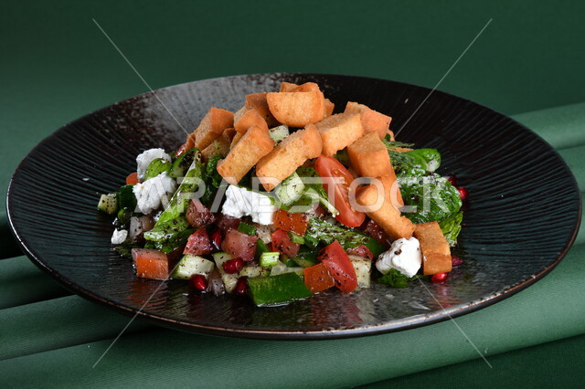 طبق سلطة الخضار اللذيذ ، مزين بقطع الخبز المقلية المقرمشة والجبنة البيضاء مصورة على خلفية خضراء ، مقبلات باردة ،  اطباق عربية ، ماكولات شرقية ، مقبلات رمضانية ، كروما ، طبق صحي ومفيد