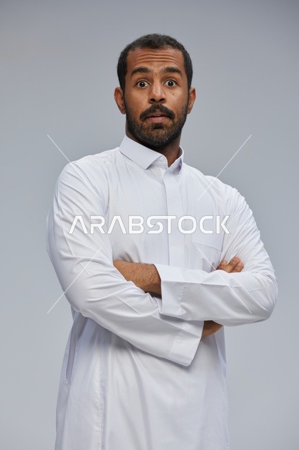 Surprised Saudi Man in White Thobe with Crossed Arms