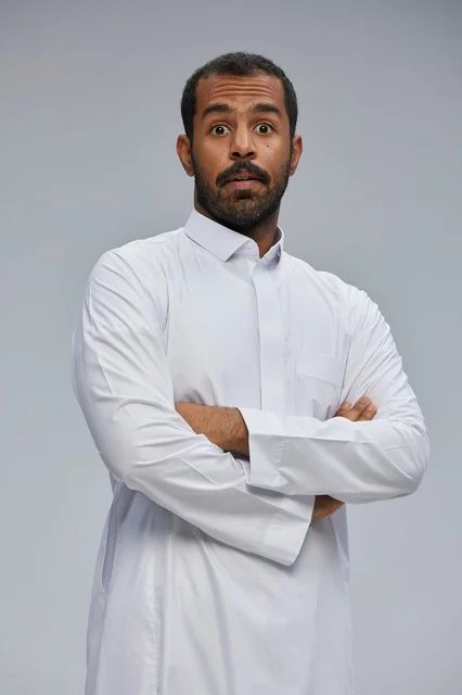 Surprised Saudi Man in White Thobe with Crossed Arms