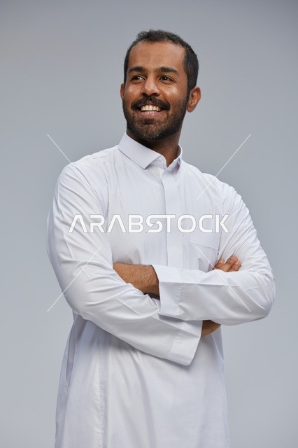 Saudi Man in White Thobe Smiling with Arms Crossed