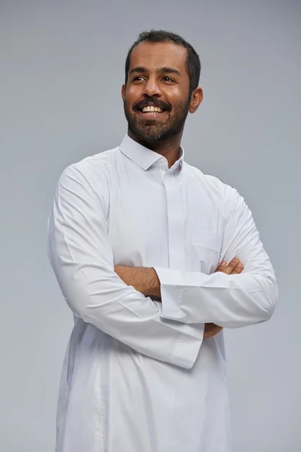 Saudi Man in White Thobe Smiling with Arms Crossed