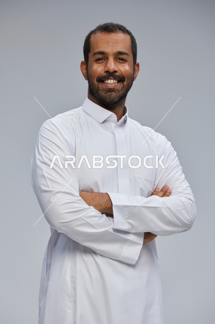 Saudi Man in White Thobe Smiling with Arms Crossed