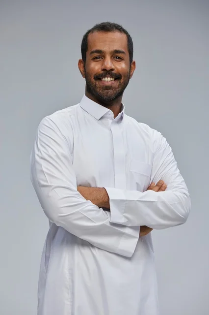 Saudi Man in White Thobe Smiling with Arms Crossed