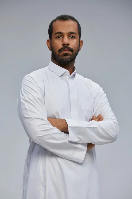 Saudi Man in Traditional White Thobe with Crossed Arms
