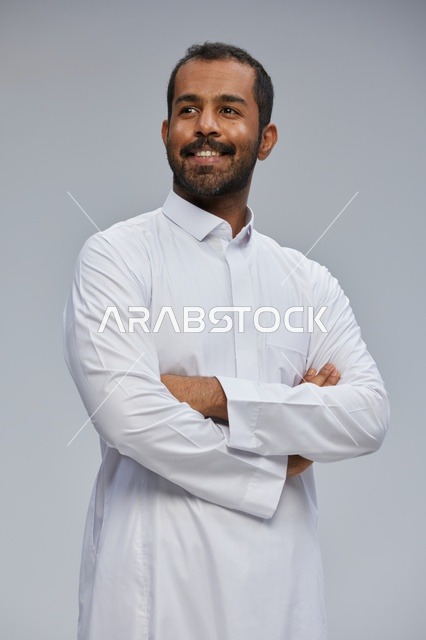 Saudi Man in Traditional White Thobe with Folded Arms