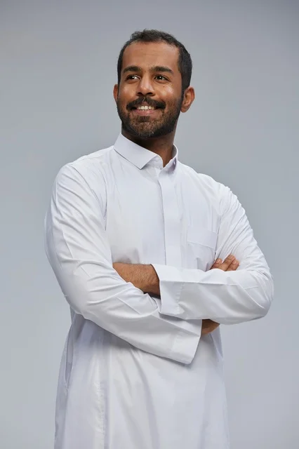 Saudi Man in Traditional White Thobe with Folded Arms