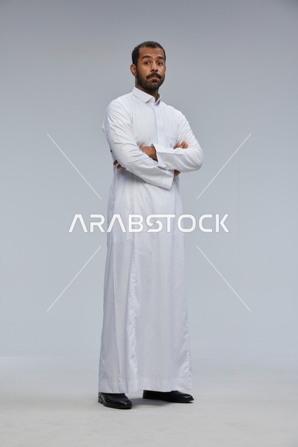 رجل سعودي بالثوب الأبيض مكتوف الذراعين